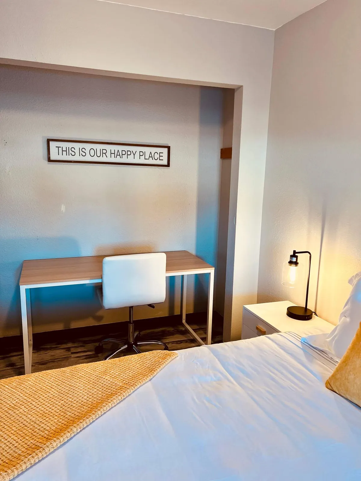A bright, cheerful bedroom with a comfortable bed, a stylish desk and chair for remote work, and a cozy lamp. The arrangement encourages both relaxation and productivity, making it ideal for families, friends, or remote workers needing a quiet retreat.